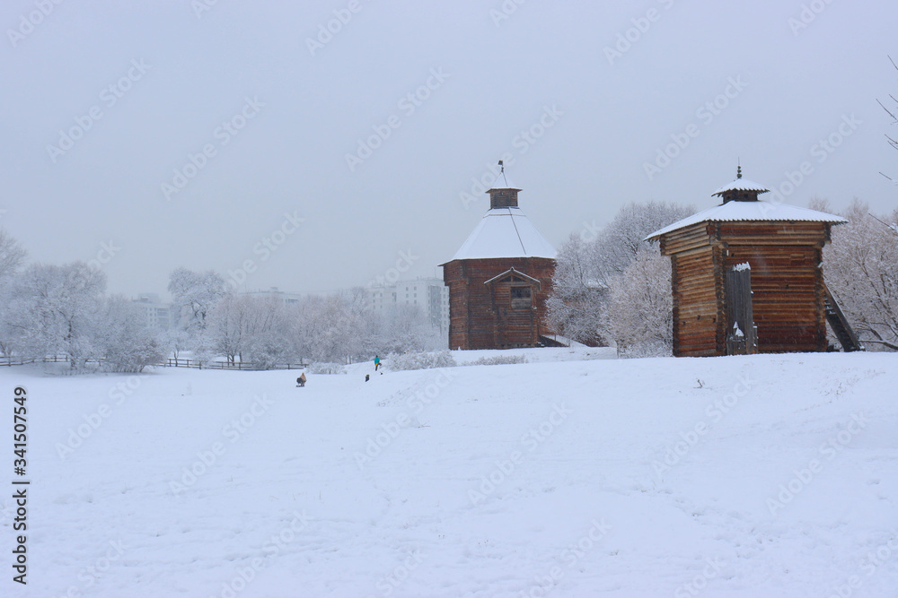 Museum of wooden architecture in Kolomenskoye during snowfall. The tower of the Bratsk fortress and the Gates of the Nikolo-Korelsky monastery in Kolomenskoye estate, Moscow, Russia