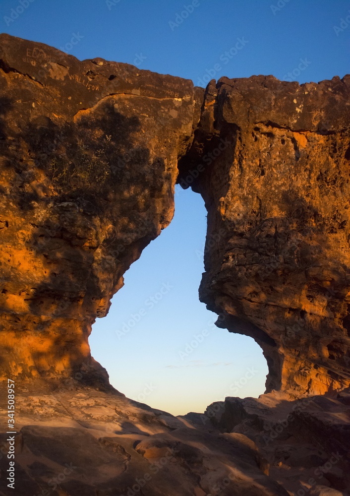Obraz premium Sunset view trhouogh the rock hole (Pedra furada), in Portal da chapada, a trourist attraction in Chapada das mesas, Brazil