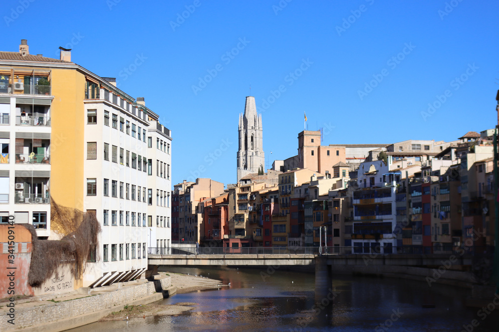 Colored houses on the Onyar River in the background of the Church of St. Felix, in Girona, Catalonia, Spain