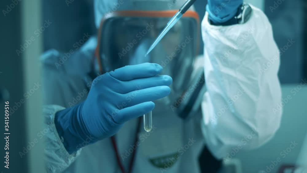 A man in hazmat uses pipette and tube while working in laboratory. Covid19, coronavirus concept. A man in hazmat uses pipette and tube while working in laboratory. Covid19, coronavirus concept.