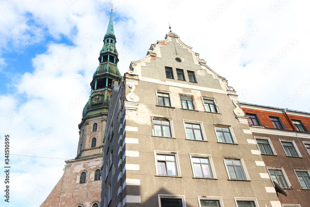 View of the tower of St. Peter's Church in Riga and the old house, Latvia