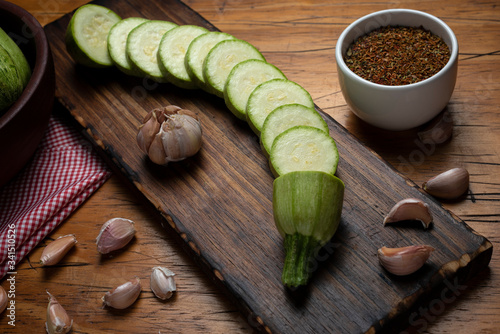Schilderij op canvas zucchini slices on wooden board garlic pepper and seasonings