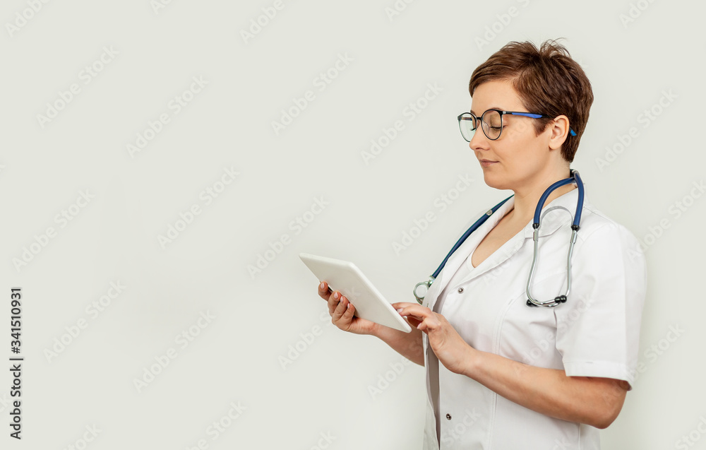 Portrait of a female doctor using her digital tablet. Female doctor using tablet and checking with analysis Portrait of a female doctor using her digital tablet. Female doctor using tablet and checking with analysis
