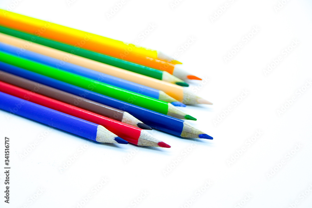 Photo of arrangement of color pencils isolated on white background. Blank space for text. Flat lay. Close up. Top view. Leadership business concept. School concept. Rainbow color pencil.