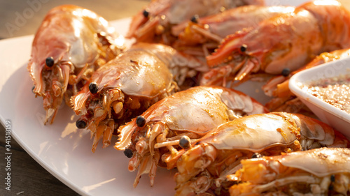 An outdoor barbecue with huge tiger prawns close up