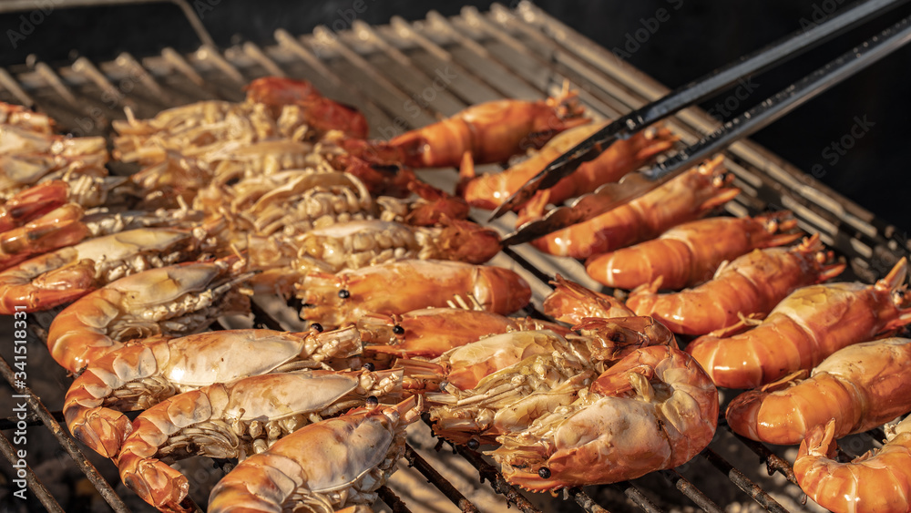An outdoor hot barbecue with huge tiger prawns