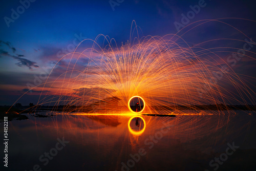 spinning burning steel wool in the River sunset,