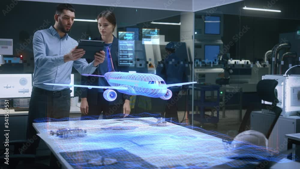 Aeronautics Factory Office Meeting Room: Engineer Holds Tablet Computer, Showing Augmented Reality Airplane Jet Engine to a Female Project Manager. Modern Industry 4.0 Research and Development Test.