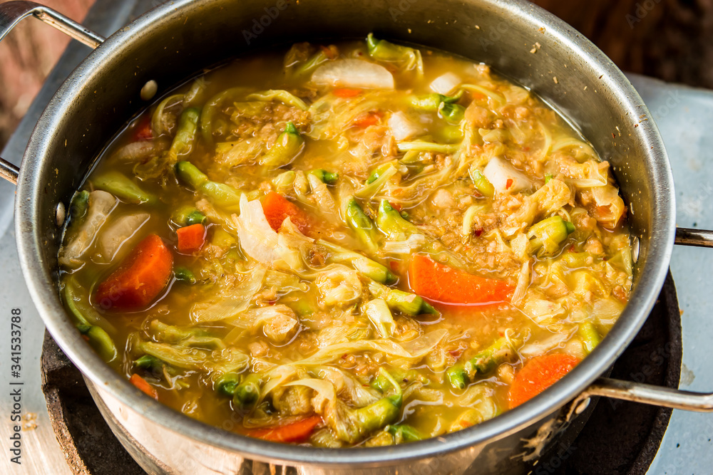 Cooking tamarind sour soup with agasta or Kang som , Thai famous food