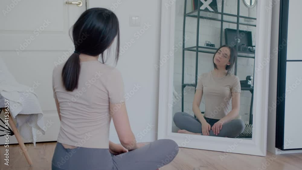 Young woman in sportswear doing stretching home with phone Young woman in sportswear doing stretching home with phone