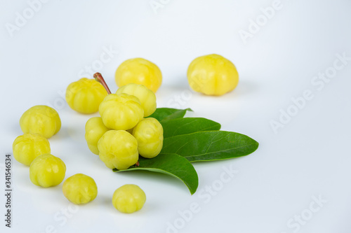 Fresh star gooseberry fruits with leaves ready to eat isolated from the tree on white background.