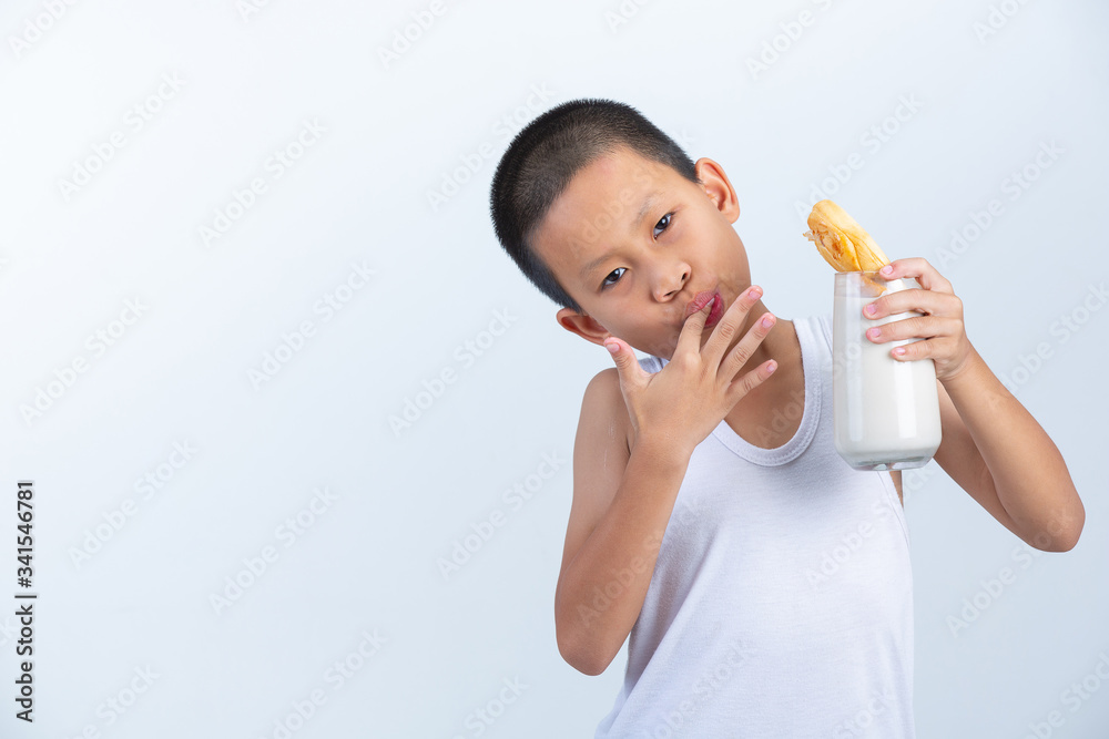 Little boy is enjoy eating waffle dipped with milk on white background. Little boy is enjoy eating waffle dipped with milk on white background.