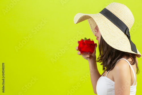 Quadro su tela Sexy girl is drinking watermalon water in sumer hot weather with hat on yellow background