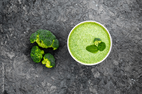 Broccoli vegan cream soup in bowl on grey table from above