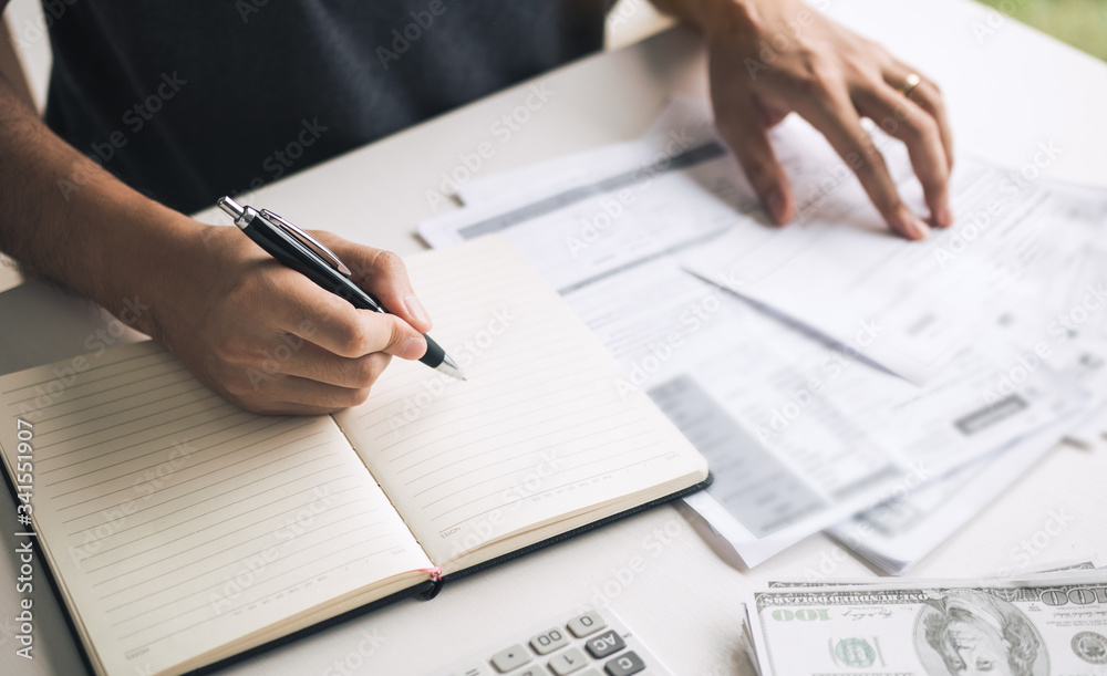 Man use calculators and documents that calculate expenses in the home office. Man use calculators and documents that calculate expenses in the home office.