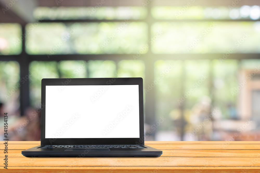 Used black laptop with blank white screen on wooden table and blurry image of coffee shop or cafe restaurant in background. Used black laptop with blank white screen on wooden table and blurry image of coffee shop or cafe restaurant in background.