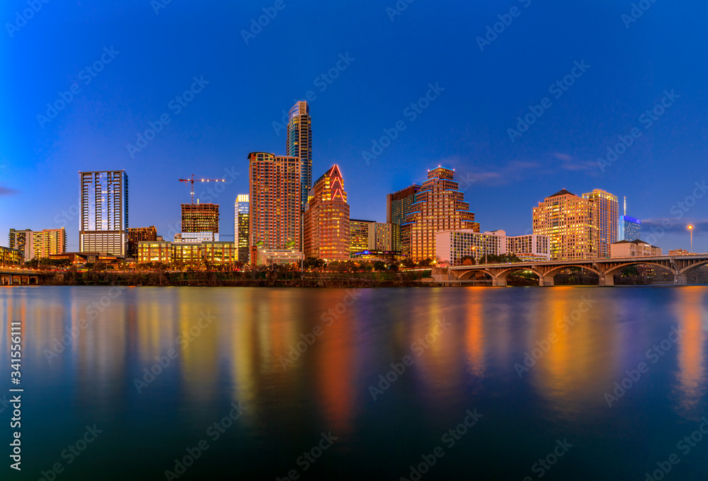 Downtown view across Lady Bird Lake or Town Lake on Colorado River at sunset golden hour in Austin, Texas, USA
