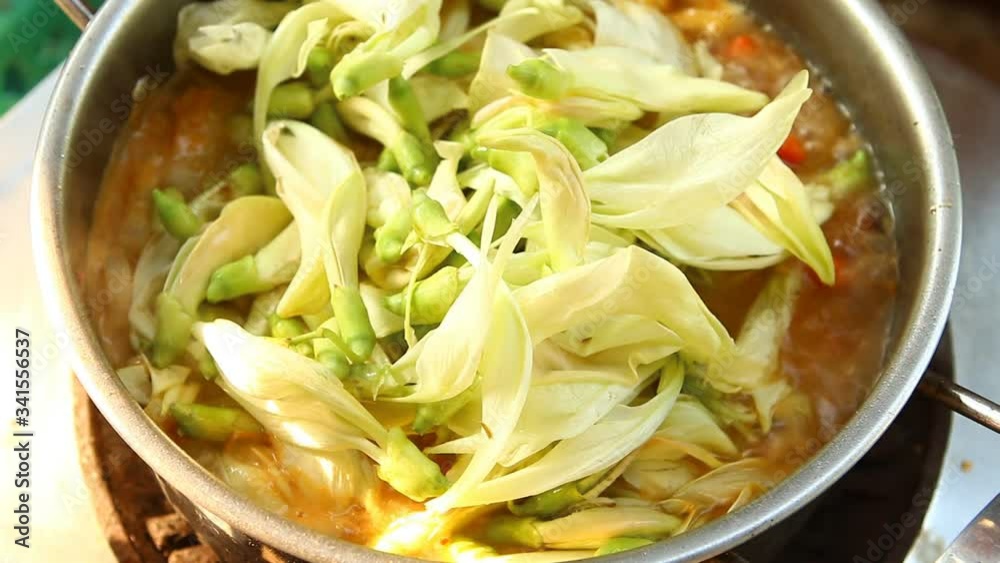Cooking tamarind sour soup with agasta or Kang som , Thai famous food