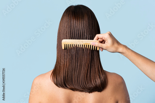 Hairstylist combing a woman's hair photo