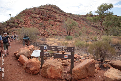 Tourists hiking with hiking sign in Kings Canyon outback central Australia