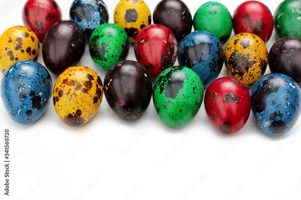 Multi-colored eggs close-up, top view. Set of easter eggs isolated on white. Easter background. Blue, red, green, yellow, purple quail eggs.