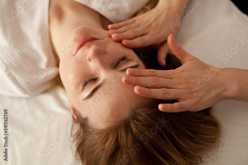 Young woman caring for her skin on the face makes massage