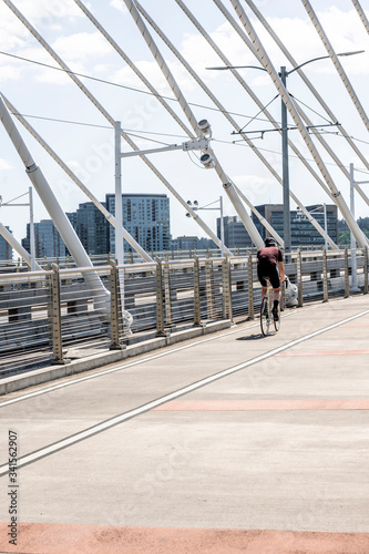 Cyclist in sportswear practicing cycling while driving along the bike path of the Tilikum Crossing Bridge preferring an active healthy lifestyle