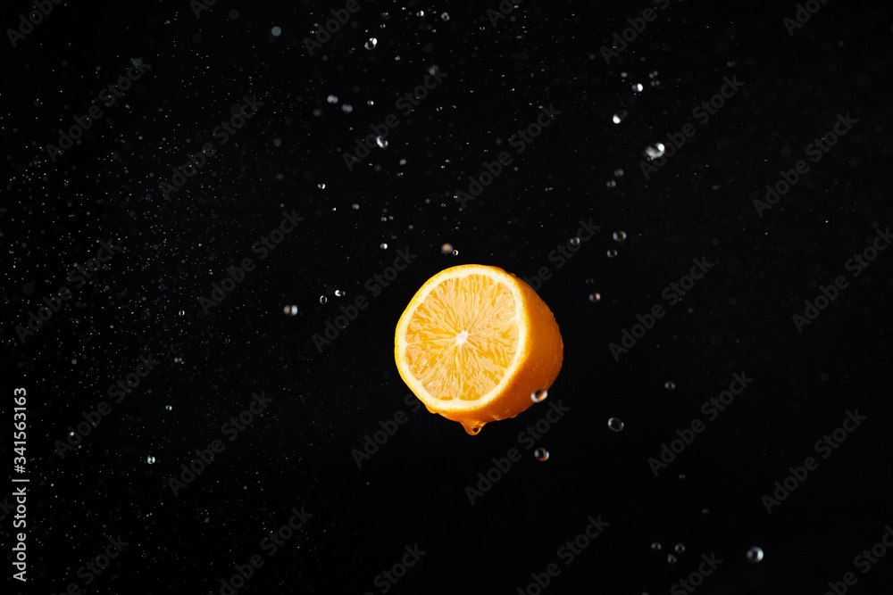Orange lemon and splashes on a black background