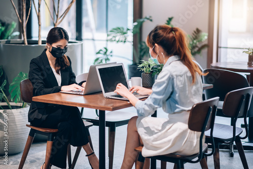 Group of Asian People Successful Teamwork Businesswoman Wearing Medical Mask and Working with Laptop. Work from Private Home Office Social Distancing among Coronavisus Outbreak Situation