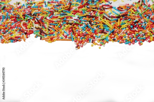 Obraz na płótnie confectionery powder for decorating cupcakes and cakes. Decorative sprinkles border on white background. Multicolor Sugar confectionery powder in the corner. Scattered sweet sugar sticks and balls. w salonie