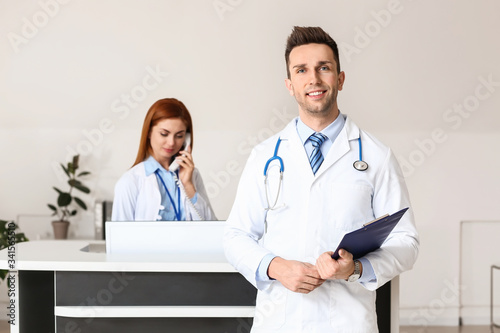 Male doctor near reception ...