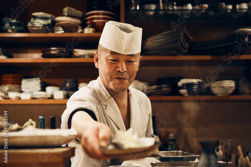 お客さんと会話をする笑顔の料理人