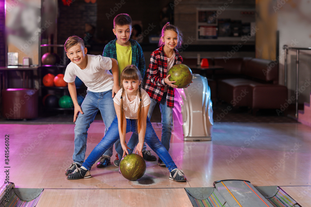 Fototapeta premium Little children playing bowling in club