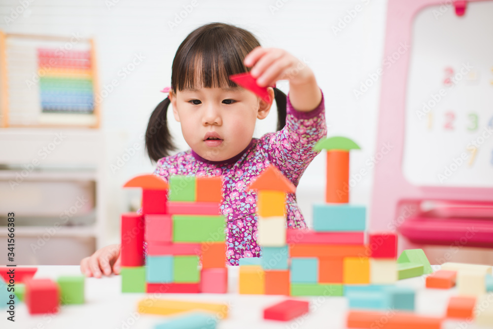 toddler girl playing creative toy blocks at home against white background toddler girl playing creative toy blocks at home against white background