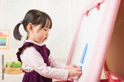 toddler girl playing creative shape blocks at home against white background