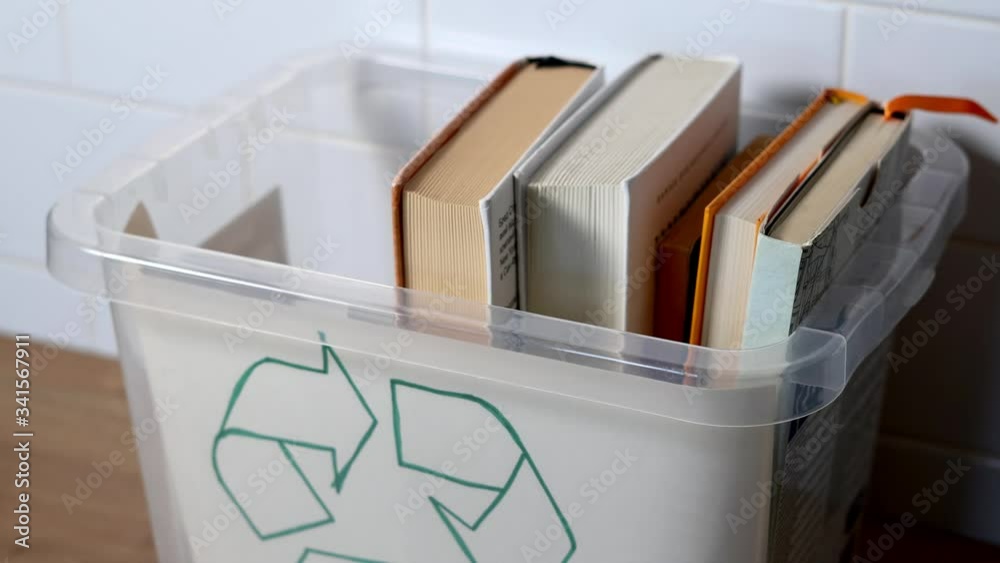 Hand putting old books in recycle bin. Paper recycle concept. Book