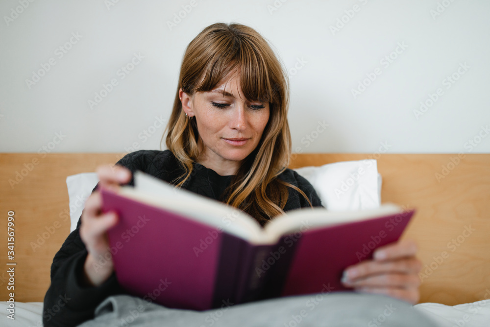 Woman reading a book in bed during coronavirus quarantine Woman reading a book in bed during coronavirus quarantine
