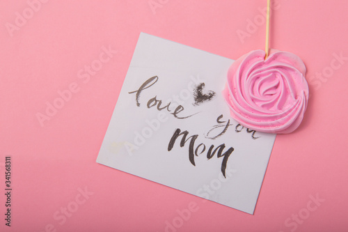 Love you mom handwritten inscription. Hand drawn lettering, calligraphy. card with spring tree brunch background, Valentine, Mother's Day.