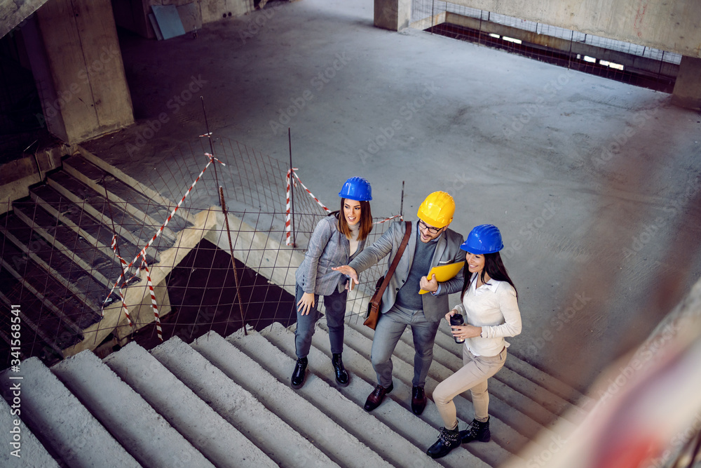 custom made wallpaper toronto digitalGroup of successful young innovative architects climbing the stairs and talking about project. Building in construction process interior.