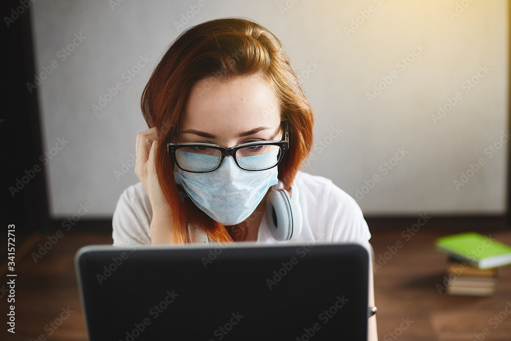 Woman working from home wearing protective mask. Student in quarantine for coronavirus wearing protective mask. Working from home