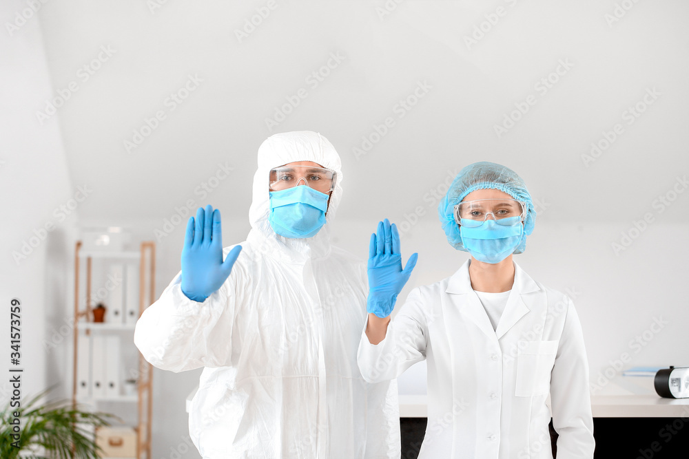 Receptionist with doctor showing stop gesture in hall of clinic Receptionist with doctor showing stop gesture in hall of clinic