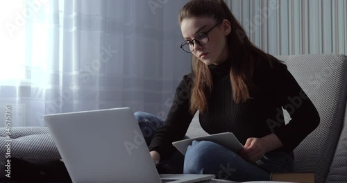 girl working on laptop at home on sofa. stay at home and work remotely. isolation at home.