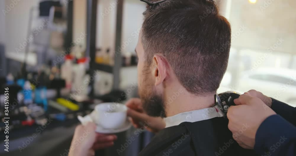 Client drinking coffee visiting barber shop Client drinking coffee visiting barber shop