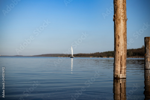 Segelboot und Holzpflöcke im Wasser- Buhnen