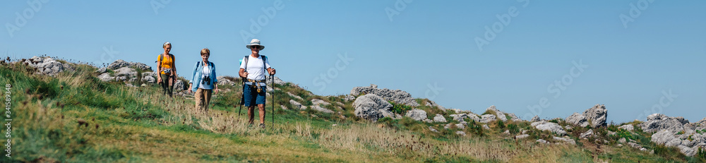 Group of three people practicing trekking outdoors - obrazy, fototapety, plakaty 
