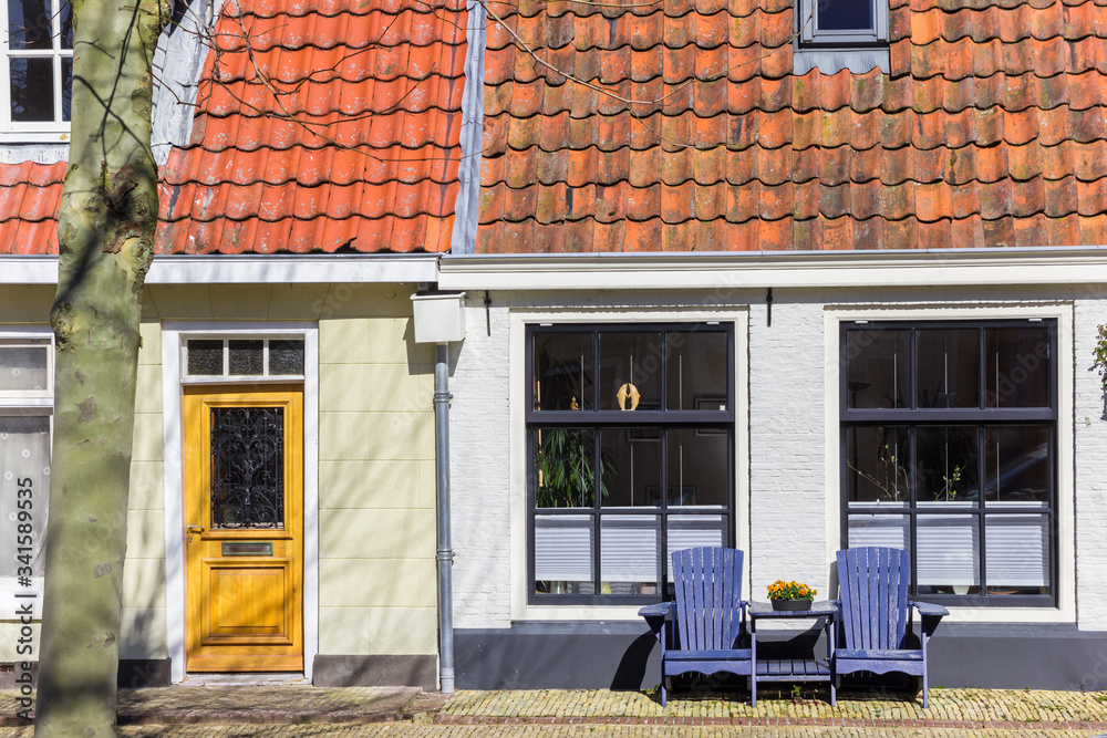 Wooden chairs in front of a house in Harlingen, Netherlands