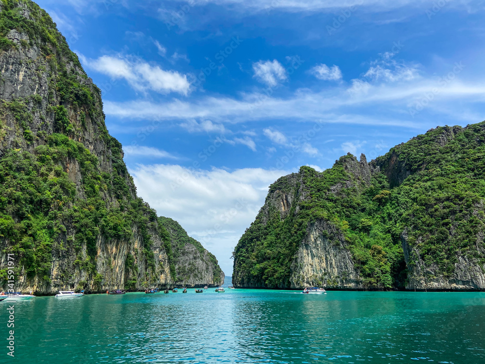 Andaman Sea next to paradise island Pele lagoon Phi Phi archipelago Thailand clear blue water and beautiful sky with clouds. National Park which is visited sea excursions and tours, desktop background
