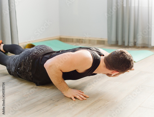young man making sport exercises at home