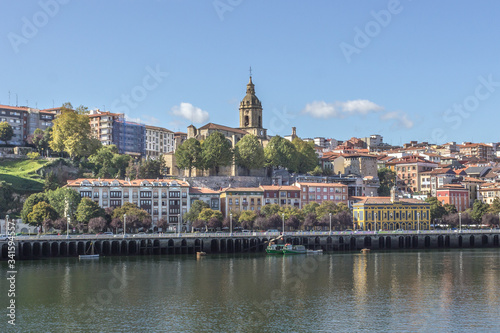 Euro-trip. The ancient city of Spain. City on the banks of the river Nervion. The city of Portugal in the Basque Country. Houses with red tiles. Dome of the catholic cathedral in cityscape.