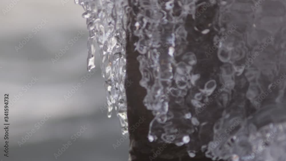 Icicles On Rocks Are Starting To Melt Because Of The Water Splashes In the Ocean .- closeup shot Icicles On Rocks Are Starting To Melt Because Of The Water Splashes In the Ocean .- closeup shot